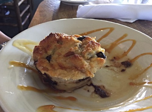 A baked dessert with a golden crust, served on a plate with a drizzle of caramel sauce.