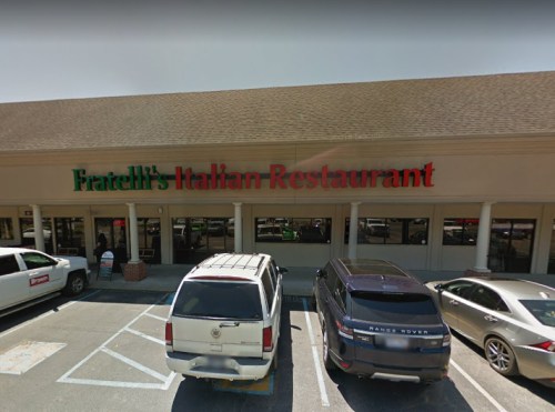 Exterior view of Fratelli's Italian Restaurant, featuring a sign in red and green, with parked cars in front.