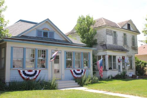 Two houses side by side, one well-maintained with patriotic decorations, the other weathered and in disrepair.
