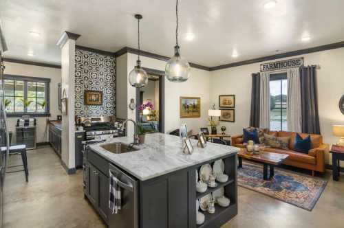 Modern kitchen with a marble island, farmhouse decor, and a cozy living area featuring a sofa and decorative accents.