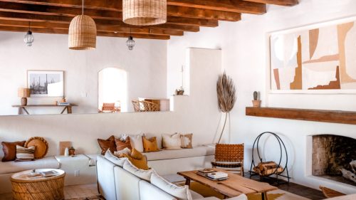 Bright, modern living room with wooden beams, cozy seating, and earthy decor elements. Warm and inviting atmosphere.