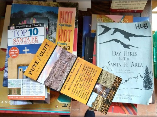 A collection of travel books and brochures about Santa Fe, including hiking guides and hot springs information.