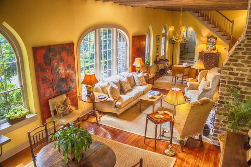 Cozy living room with warm lighting, comfortable seating, and large windows overlooking greenery. Elegant decor throughout.