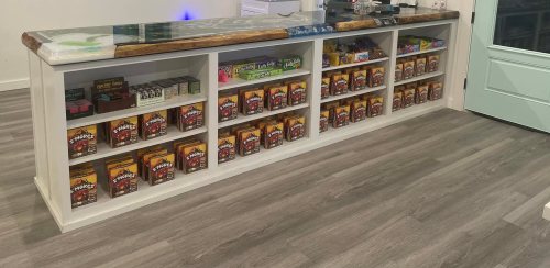 A display counter with various colorful boxes neatly arranged on shelves, set in a modern shop interior.