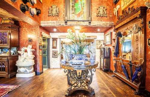 A richly decorated room featuring ornate furniture, artwork, and a floral centerpiece on a decorative table.