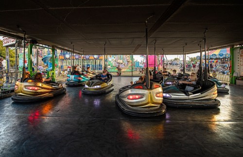 A lively bumper car ride at an amusement park, with colorful cars and excited riders enjoying the fun.