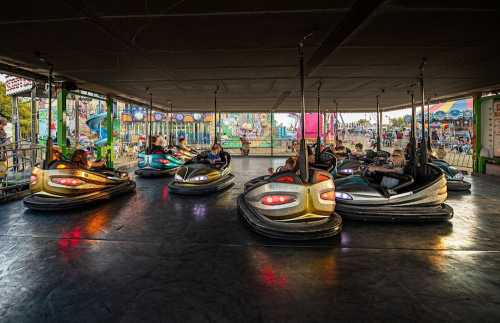 A lively bumper car ride at an amusement park, with colorful cars and excited riders enjoying the fun.