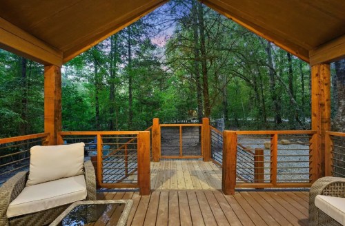 Cozy wooden deck overlooking a serene forest, with comfortable seating and a peaceful atmosphere.