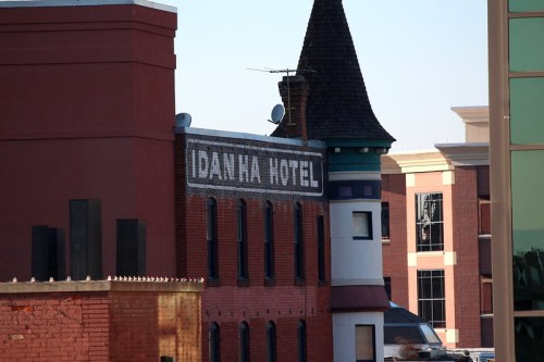 Historic Idanha Hotel building with a turret, surrounded by modern architecture.