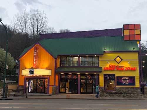 Colorful building exterior of a fun zone, featuring bright purple and orange walls, with a green roof and marquee.