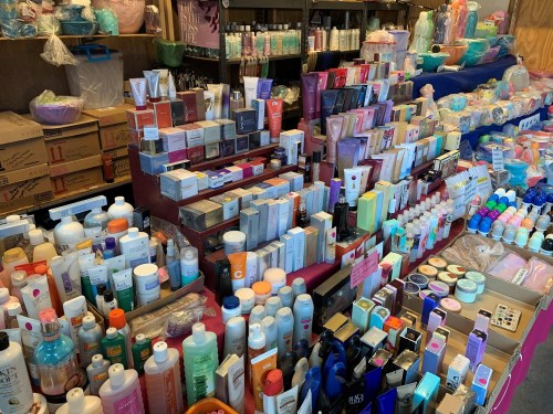 A vibrant display of various skincare and beauty products arranged on tables in a market setting.