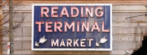 Neon sign for Reading Terminal Market, featuring bold red letters on a blue background.