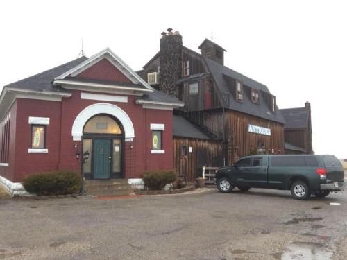 A rustic building with a red brick facade and wooden upper structure, featuring a sign that reads "Antonio's."