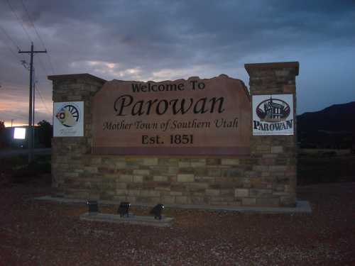 Welcome sign for Parowan, Utah, established in 1851, with a scenic background and evening sky.