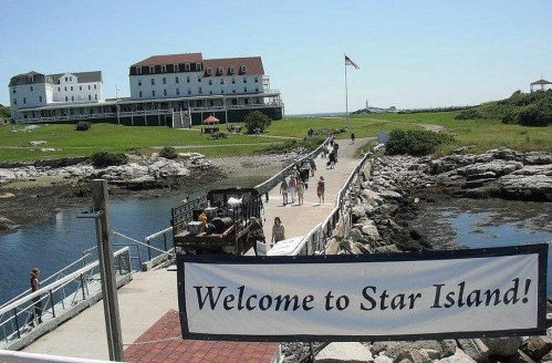 A scenic view of Star Island with a welcome sign, a dock, and a large building in the background.