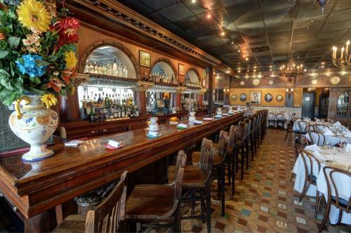 A cozy restaurant interior featuring a wooden bar, colorful decor, and tables set for dining.
