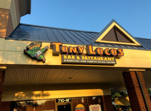 Sign for Tony Locos Bar & Restaurant, featuring American and Puerto Rican cuisine, with a colorful graphic.