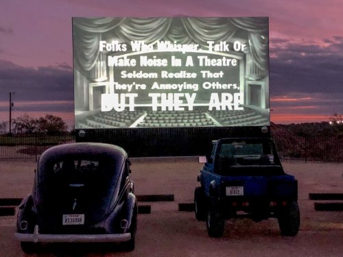 A vintage drive-in screen displays a message about noise in theaters, with two classic cars in the foreground at sunset.