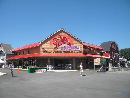 A large wooden building with a red roof, labeled "World's Largest General Store," under a clear blue sky.