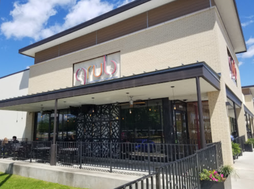 Exterior view of a restaurant named "grub," featuring a modern design and outdoor seating area.