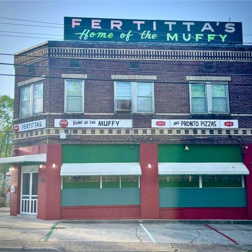 Exterior of Fertitta's restaurant, featuring a sign that reads "Home of the Muffy" and green awnings.