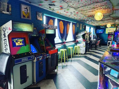 Colorful arcade with vintage game machines, bright decor, and seating along a patterned floor.