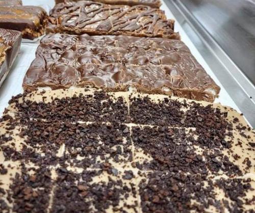 A close-up of two types of fudge: one smooth and chocolatey, the other topped with crushed cocoa nibs.