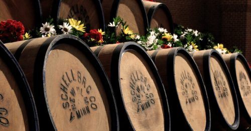 Wooden barrels stacked with flowers and greenery, featuring the logo "Schell Bros. Co." on the front.