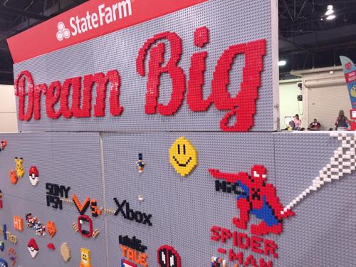 A colorful wall made of LEGO bricks featuring the words "Dream Big" and various characters, including Spider-Man.