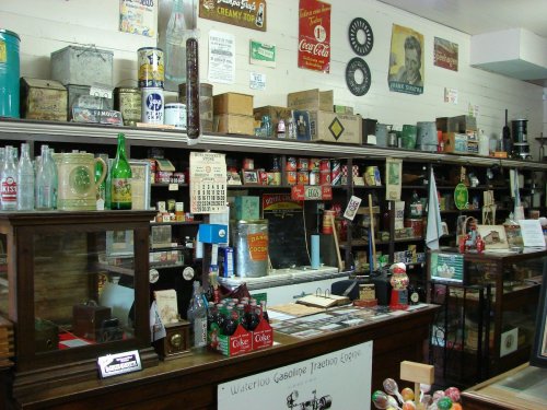A vintage store display filled with old bottles, cans, and memorabilia, showcasing nostalgic items from the past.