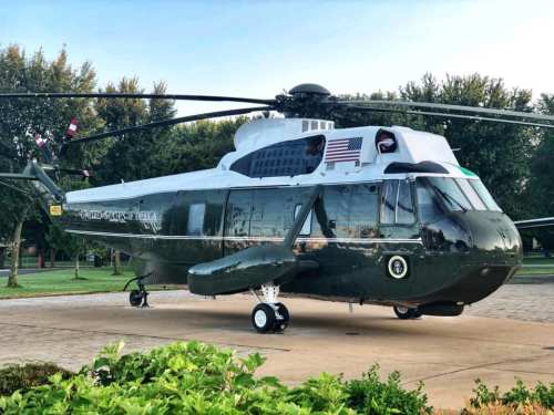 A green and white helicopter with "United States of America" written on the side, parked on a tarmac.