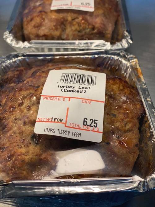 Two cooked turkey loaves in aluminum trays, with a price tag of $6.25 from Hinks Turkey Farm.
