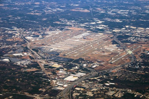 Aerial view of an airport with runways, taxiways, and surrounding urban areas.