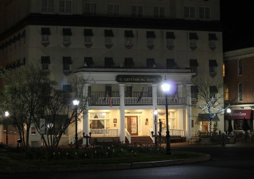 Gettysburg Hotel illuminated at night, featuring a welcoming entrance and decorative lights.