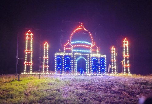 A colorful light display resembling the Taj Mahal, set against a dark night sky.