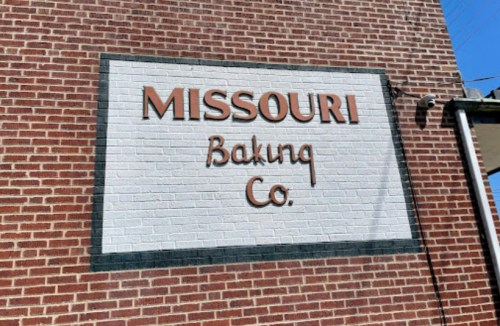 Sign on a brick wall reading "Missouri Baking Co." in orange and black lettering.