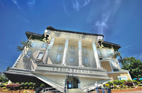 A whimsical upside-down building with columns and the sign "WonderWorks" against a blue sky.