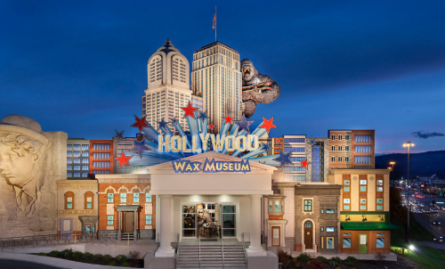 Exterior of the Hollywood Wax Museum, featuring iconic buildings and a giant gorilla statue against a twilight sky.