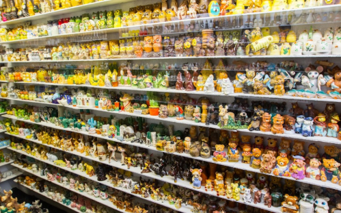A colorful display of various ceramic figurines arranged on shelves, featuring animals and whimsical designs.