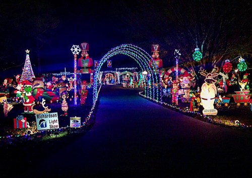 Colorful holiday lights and decorations line a pathway, creating a festive atmosphere at the Richardson Light Show.