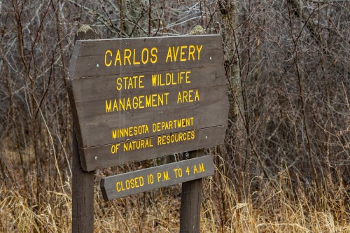 Sign for Carlos Avery State Wildlife Management Area, Minnesota, indicating hours and management details.