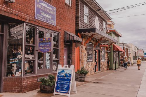 A charming street scene featuring shops with colorful signs and storefronts, inviting visitors to explore.
