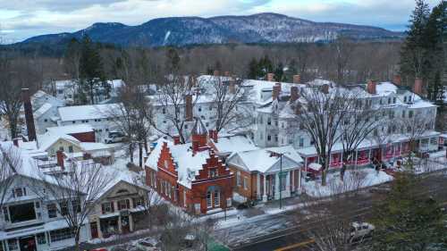 A snowy village scene with historic buildings and mountains in the background, showcasing a winter landscape.