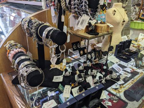 A display of various jewelry pieces, including bracelets, earrings, and rings, arranged on stands and in boxes.