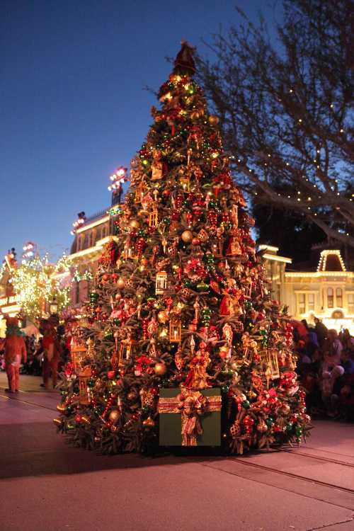 A beautifully decorated Christmas tree adorned with ornaments and lights, set against a festive evening backdrop.