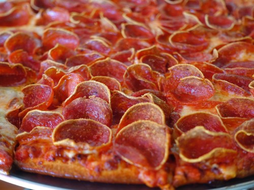 Close-up of a pepperoni pizza with a crispy crust and abundant slices of pepperoni on top.