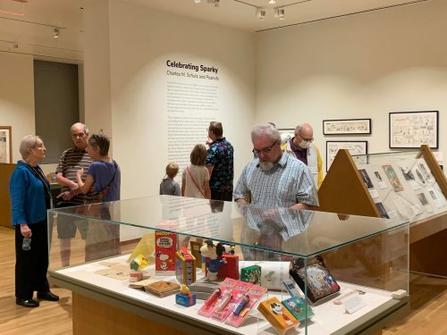 Visitors explore an exhibit titled "Celebrating Sparky," featuring displays and artifacts in a museum setting.