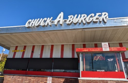 Exterior of Chuck-A-Burger restaurant with a bright blue sky and "OPEN" sign in the window.