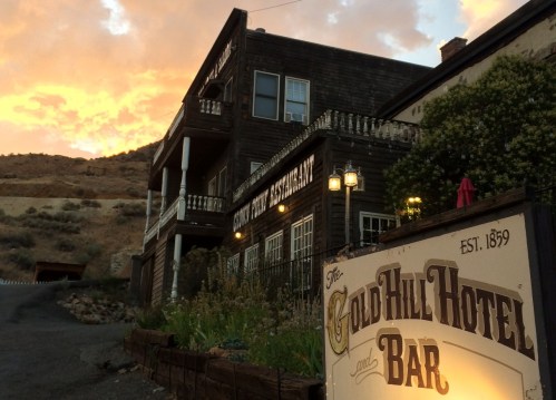 Historic Gold Hill Hotel and Bar at sunset, showcasing wooden architecture and a welcoming sign. Established 1859.