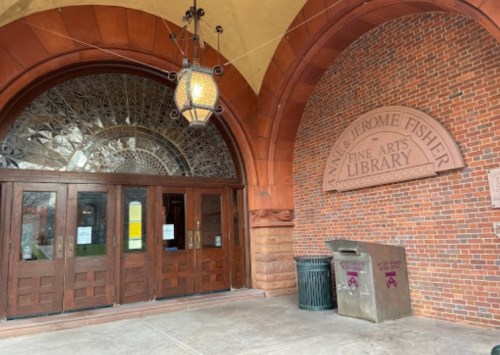 Entrance to the Anne & Jerome Fisher Fine Arts Library, featuring a decorative arch and wooden doors.